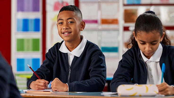 child at school desk smiling