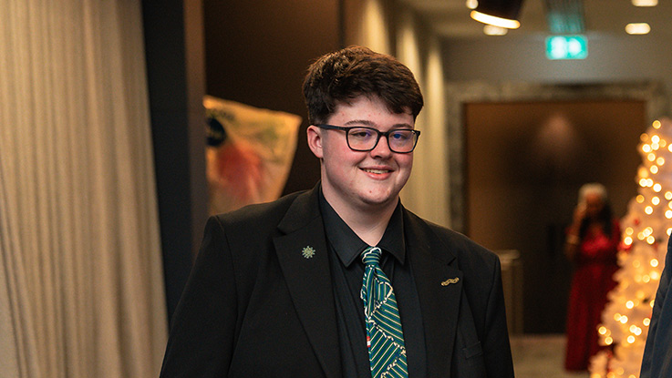 a young boy in a suit wearing a blue tie