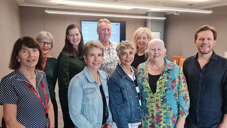 a group of senior leadership team posing together smiling