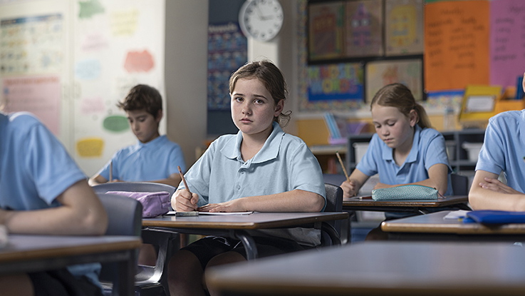 Girl sitting at desk looking sad