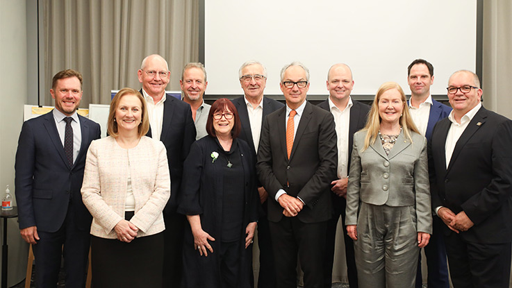 a group of people standing together in corporate attire and smiling