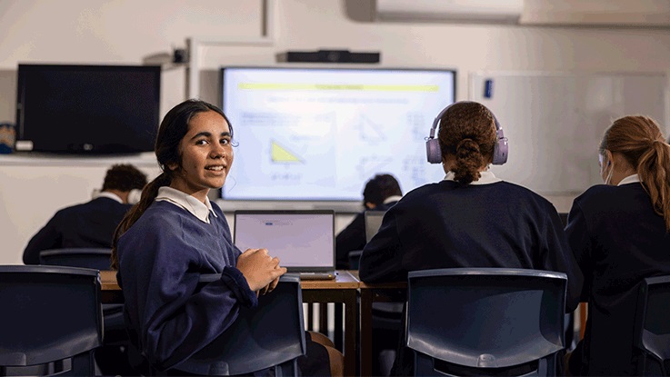 High school kids on computers sitting in classroom