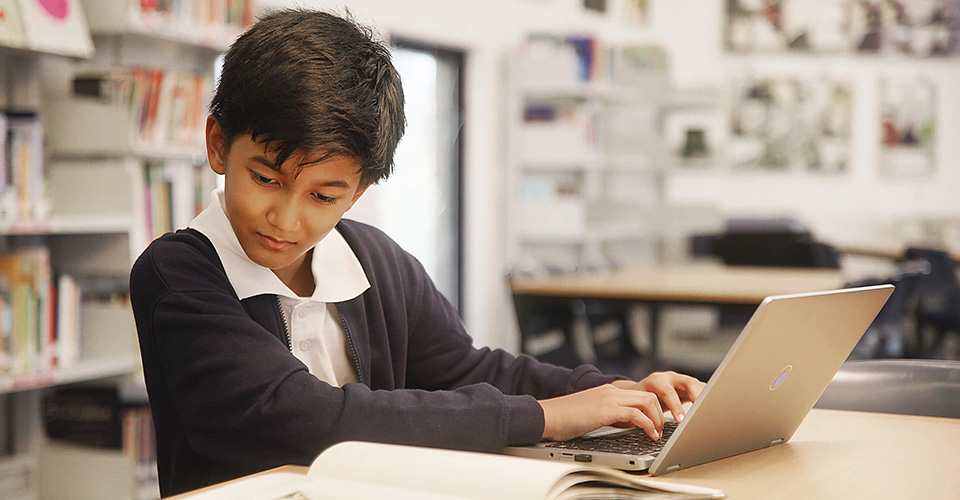 boy using laptop in library