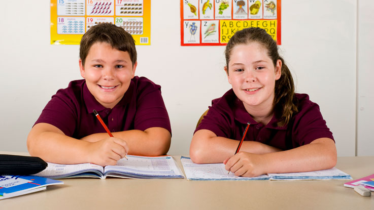 Students at a desk writing