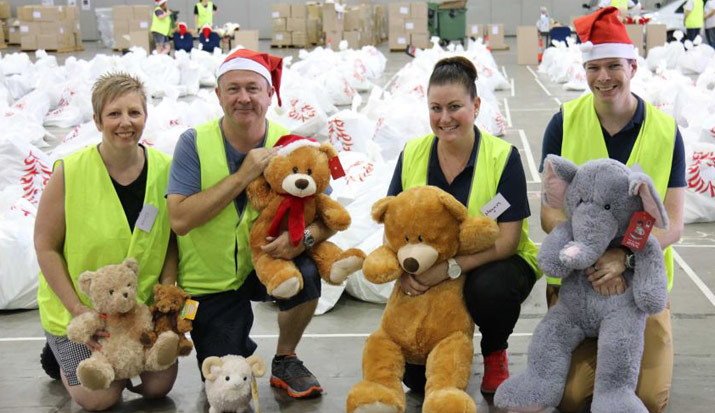 a group of people wearing hi vis vests holding plush toys