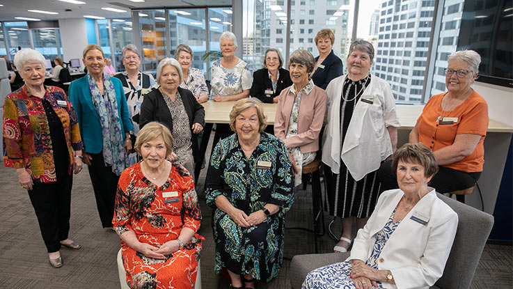 a group of ladies posing together in an office space