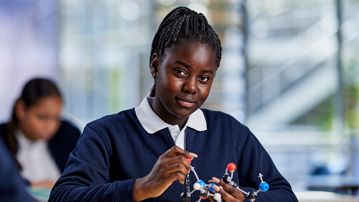 a high school student in a classroom smiling