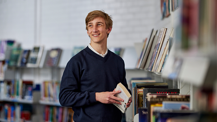 a young student smiling in a library